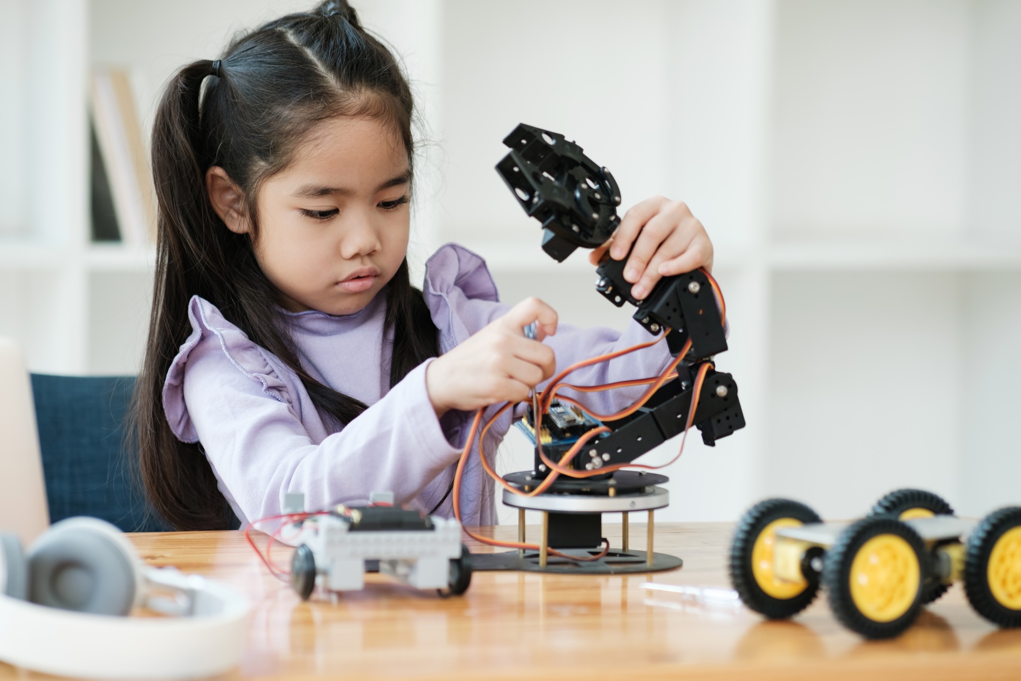 STEM education concept. Asian young girl learning robot design.
